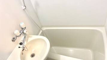 A bathroom with a white sink and bathtub.
