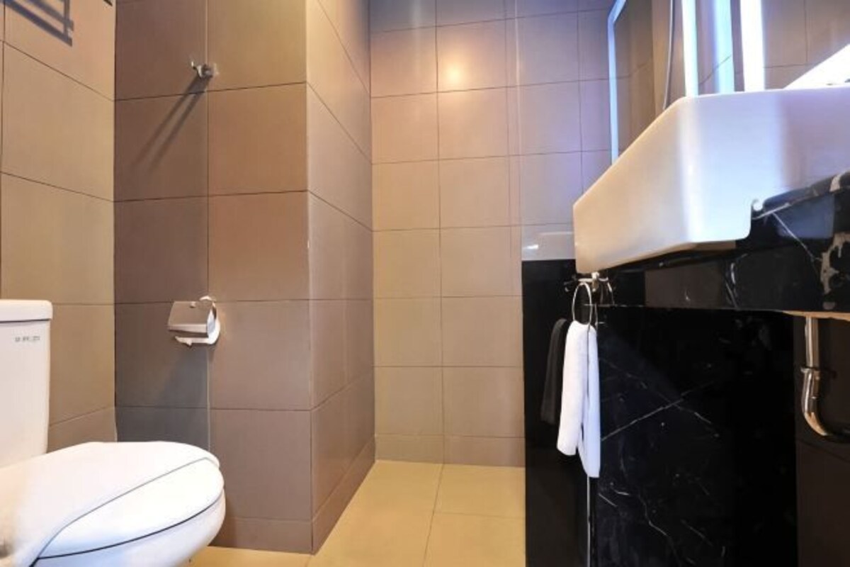 Une salle de bain avec des toilettes, une douche et un lavabo en marbre.