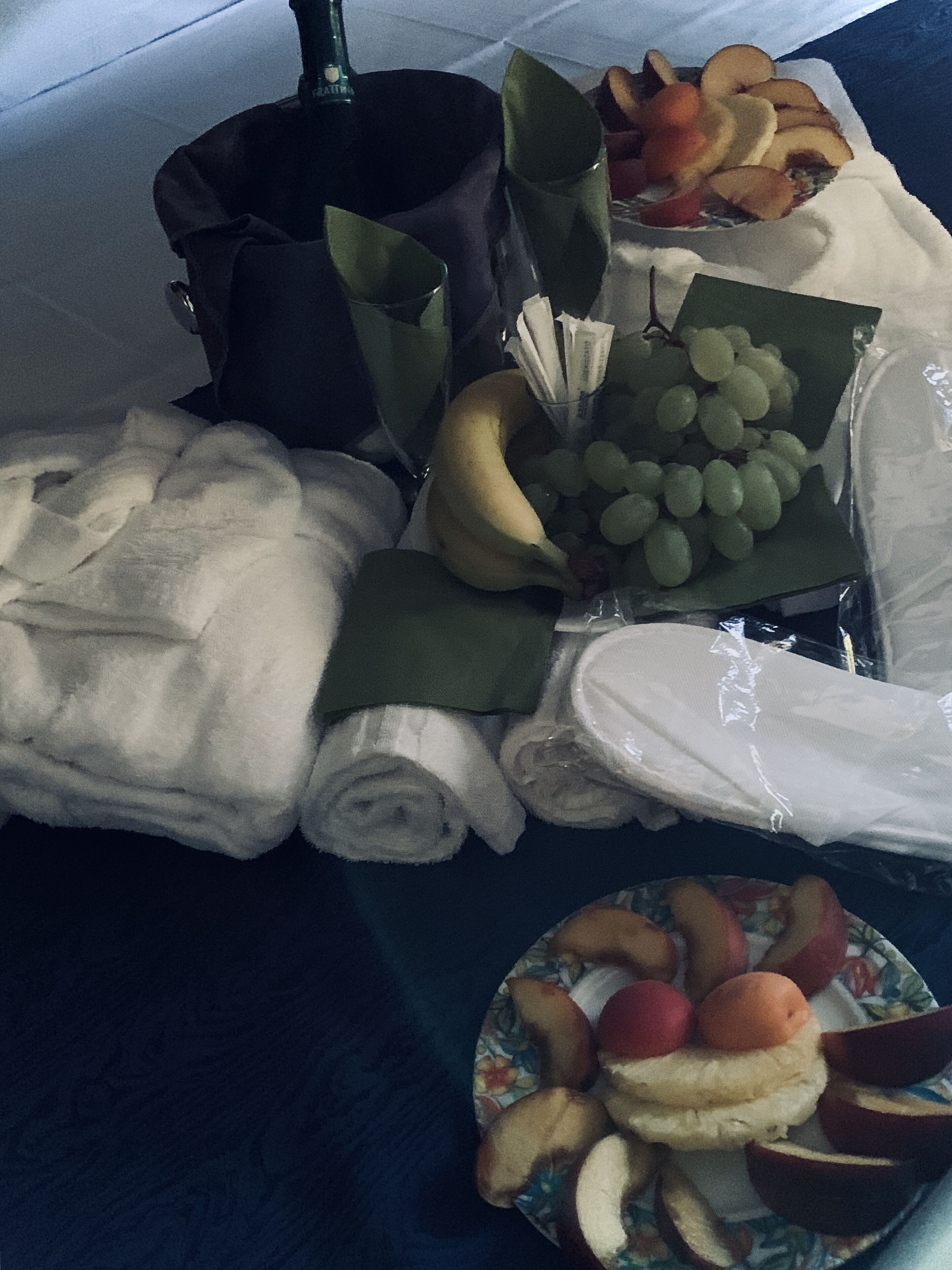 Ein ordentlich gedeckter Tisch mit Handtüchern, einer Banane, Trauben und einer Fruchtplatte.