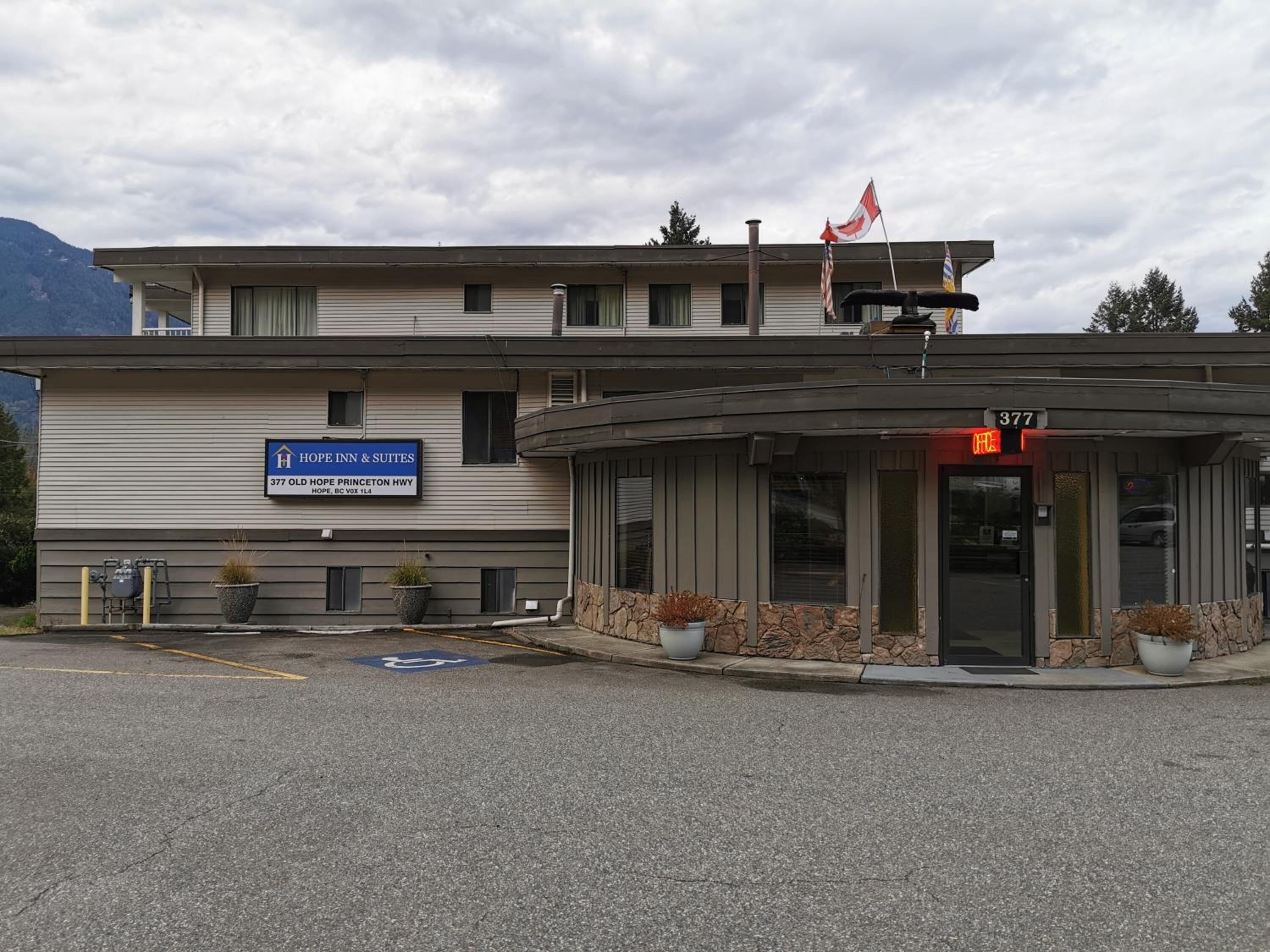 Un hotel llamado "HOPE INN & SUITES" con un cartel que indica su dirección.