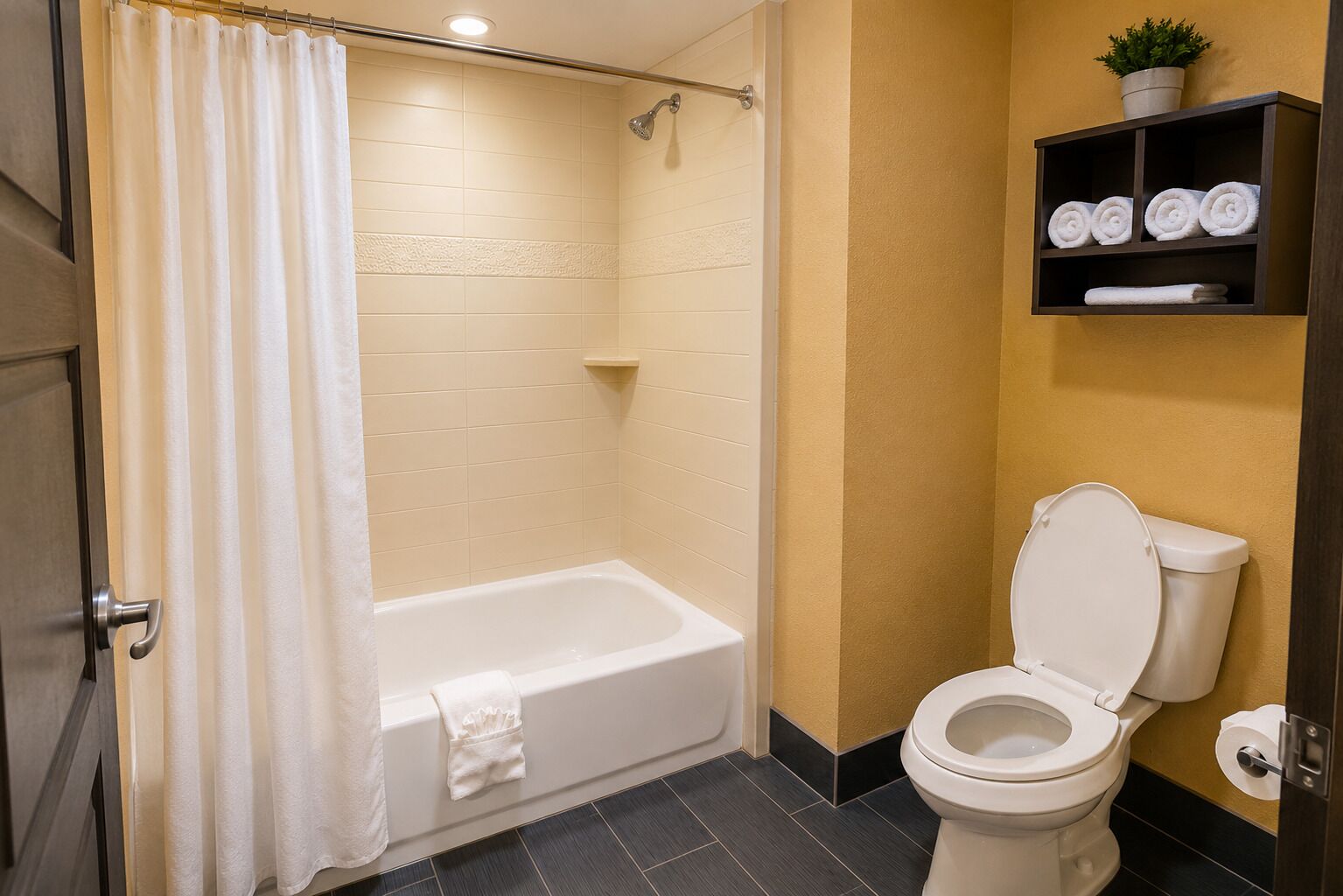 A bathroom with a bathtub, toilet, and a shelf with towels.
