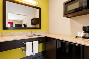 A modern bathroom with a sink, mirror, and a black toilet.