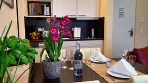 Une table dressée pour le dîner, avec une bouteille de vin, des verres et une assiette.