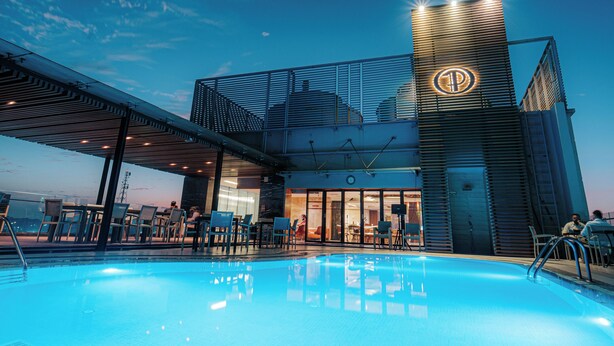 A hotel with a swimming pool, outdoor seating, and a prominent 'P' logo on the building. - The Peninsula Chittagong (Chittagong)