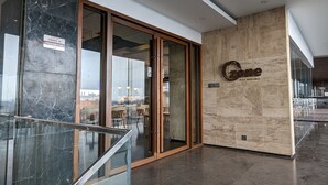 A modern bar and lounge area with marble flooring and glass doors. - The Peninsula Chittagong (Chittagong)