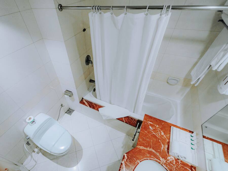 Un baño con inodoro, bañera y cortina de ducha.