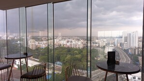 A high-rise room with large windows offering a city view. - The Peninsula Chittagong (Chittagong)