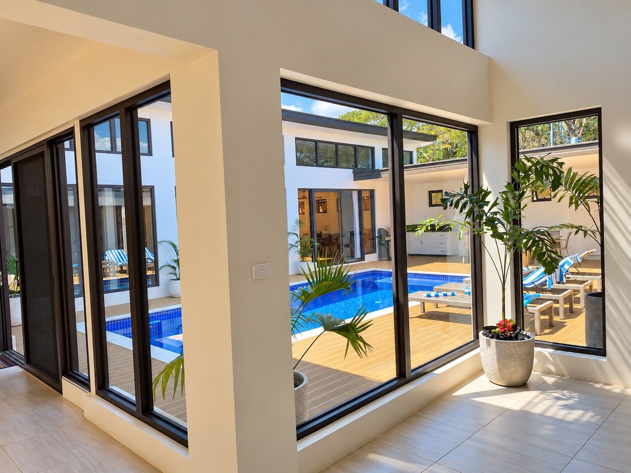 A modern interior with large sliding glass doors leading to an outdoor swimming pool area.