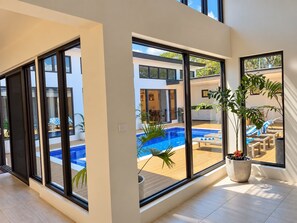 A modern interior with large sliding glass doors leading to an outdoor swimming pool area. - Sapphire Bay Fiji (Lautoka)