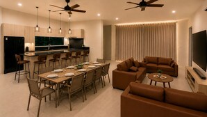 A modern living space with a dining area, kitchen, and seating area. - Sapphire Bay Fiji (Lautoka)