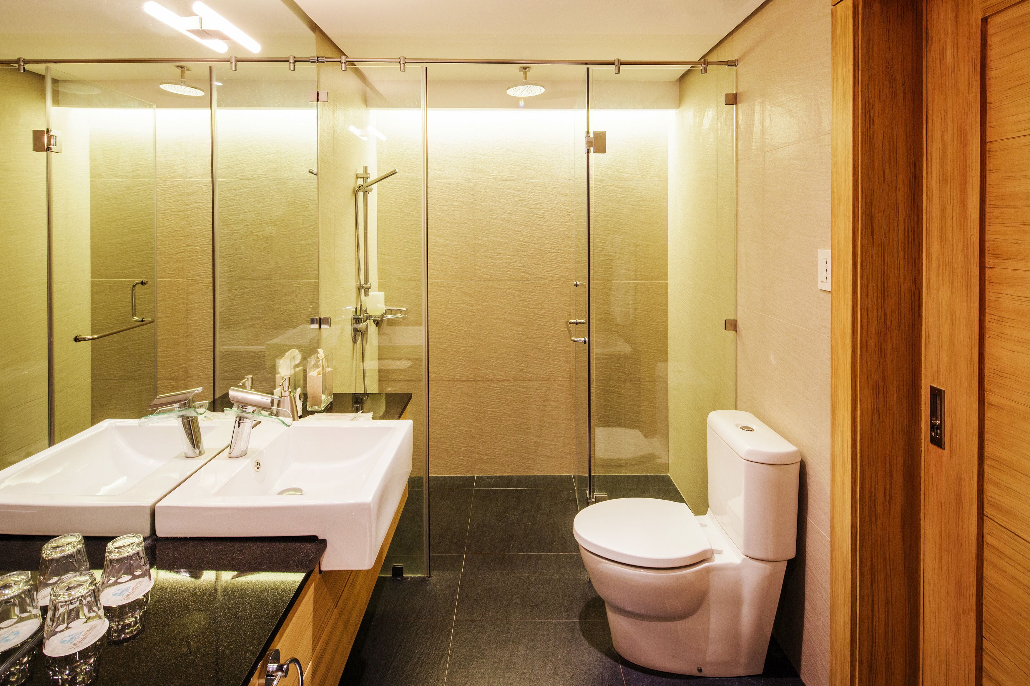 A modern bathroom with a glass-enclosed shower, a white sink, and a toilet.