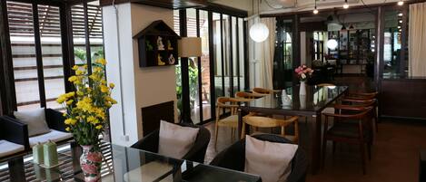 A modern interior with a glass table, wicker chairs, and a decorative vase with yellow flowers.