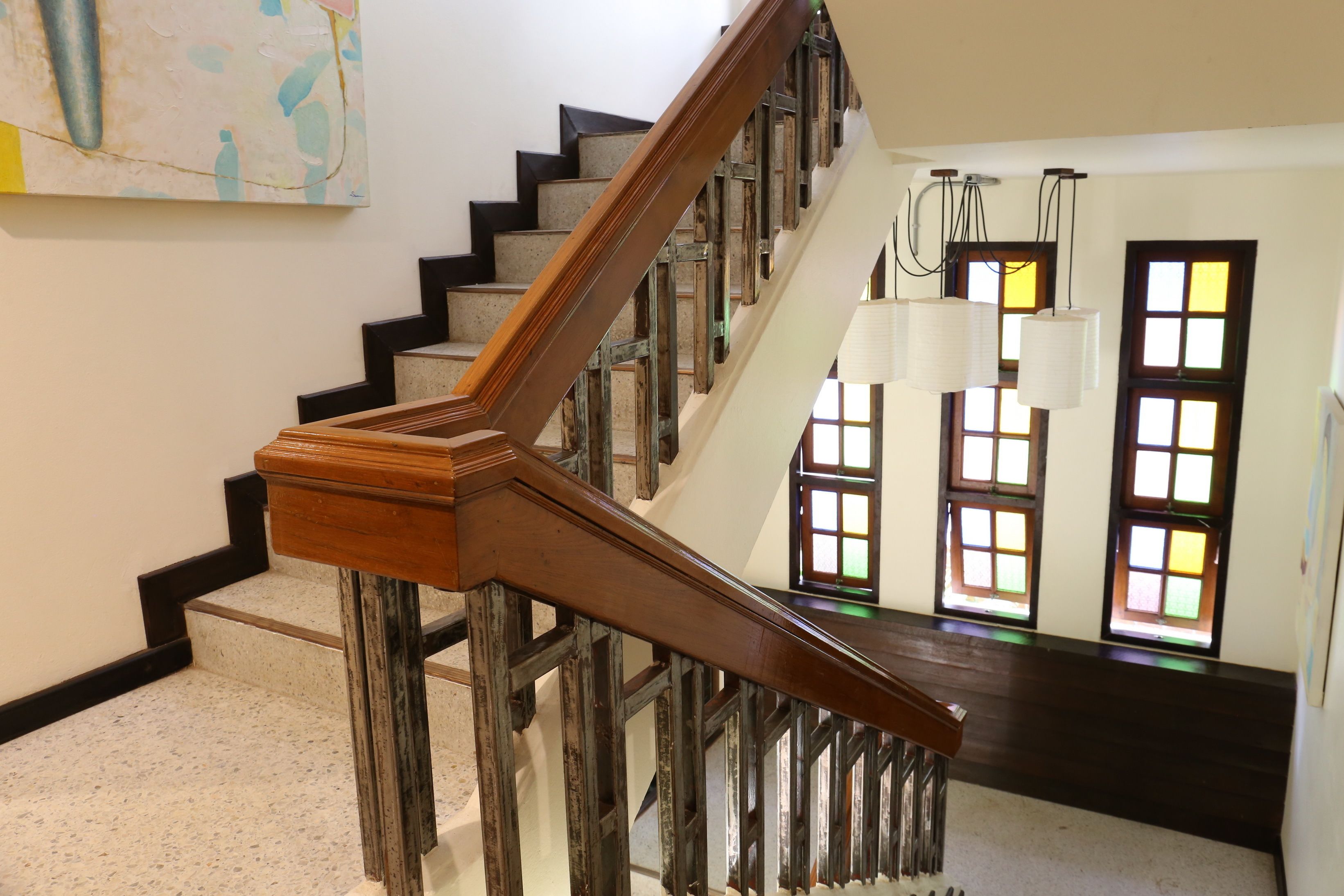 Una escalera con barandillas de madera y suelo oscuro.
