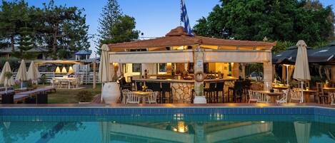 Una piscina al aire libre de temporada, sombrillas