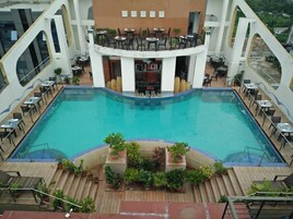 A rooftop pool area with a bar and seating.