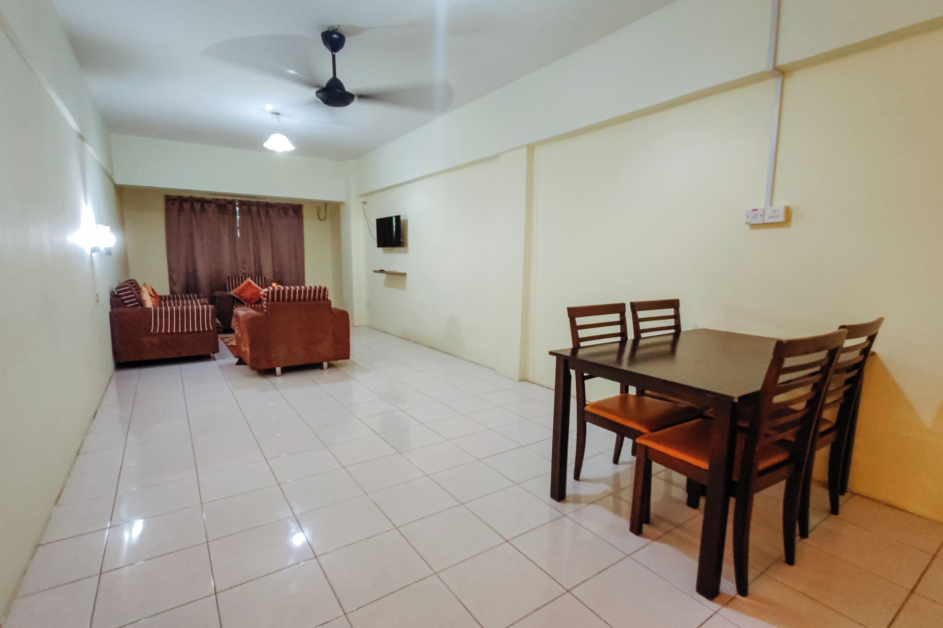 A dining area with a table and chairs, a sofa set, and a ceiling fan.
