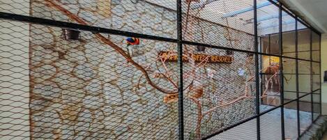 Una jaula de pájaros con un diseño de malla y un cartel que dice