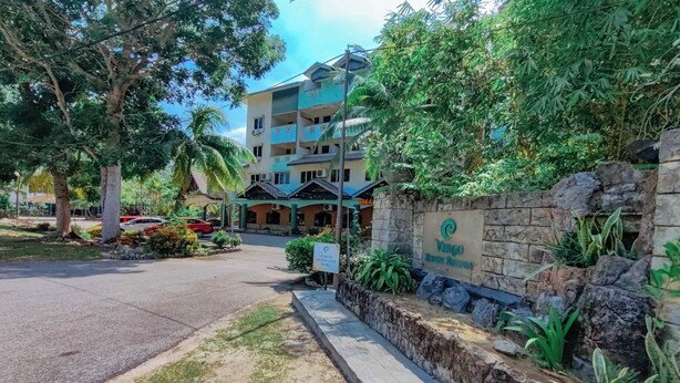 A hotel entrance with a stone wall, greenery, and a signboard. - Virgo Batik Resort Teluk Batik Lumut (Lumut)