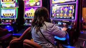Una persona jugando a una máquina tragamonedas en un casino.