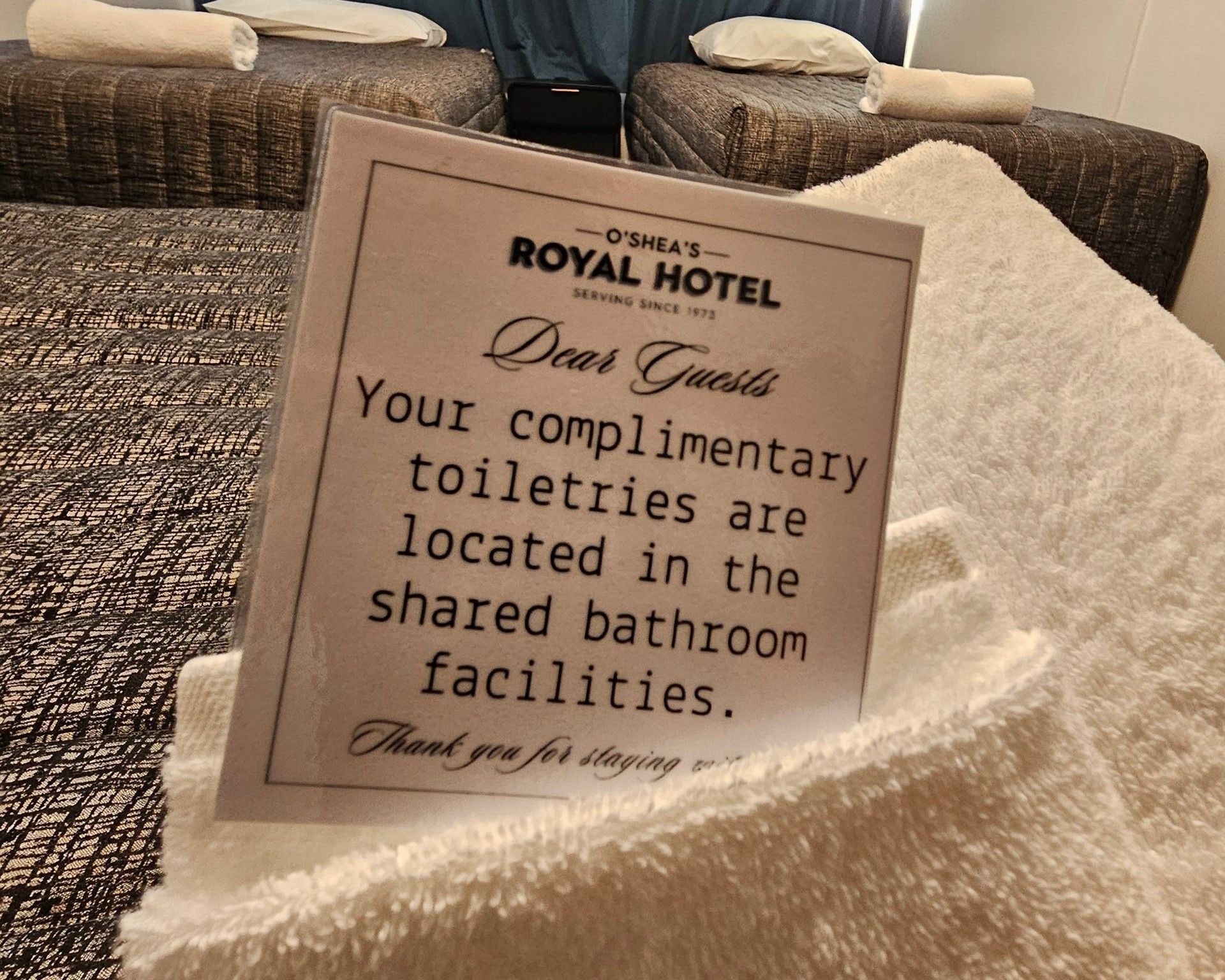 Schild in einem Hotelzimmer mit der Information, dass kostenlose Toilettenartikel in den Gemeinschaftsbädern zur Verfügung stehen.