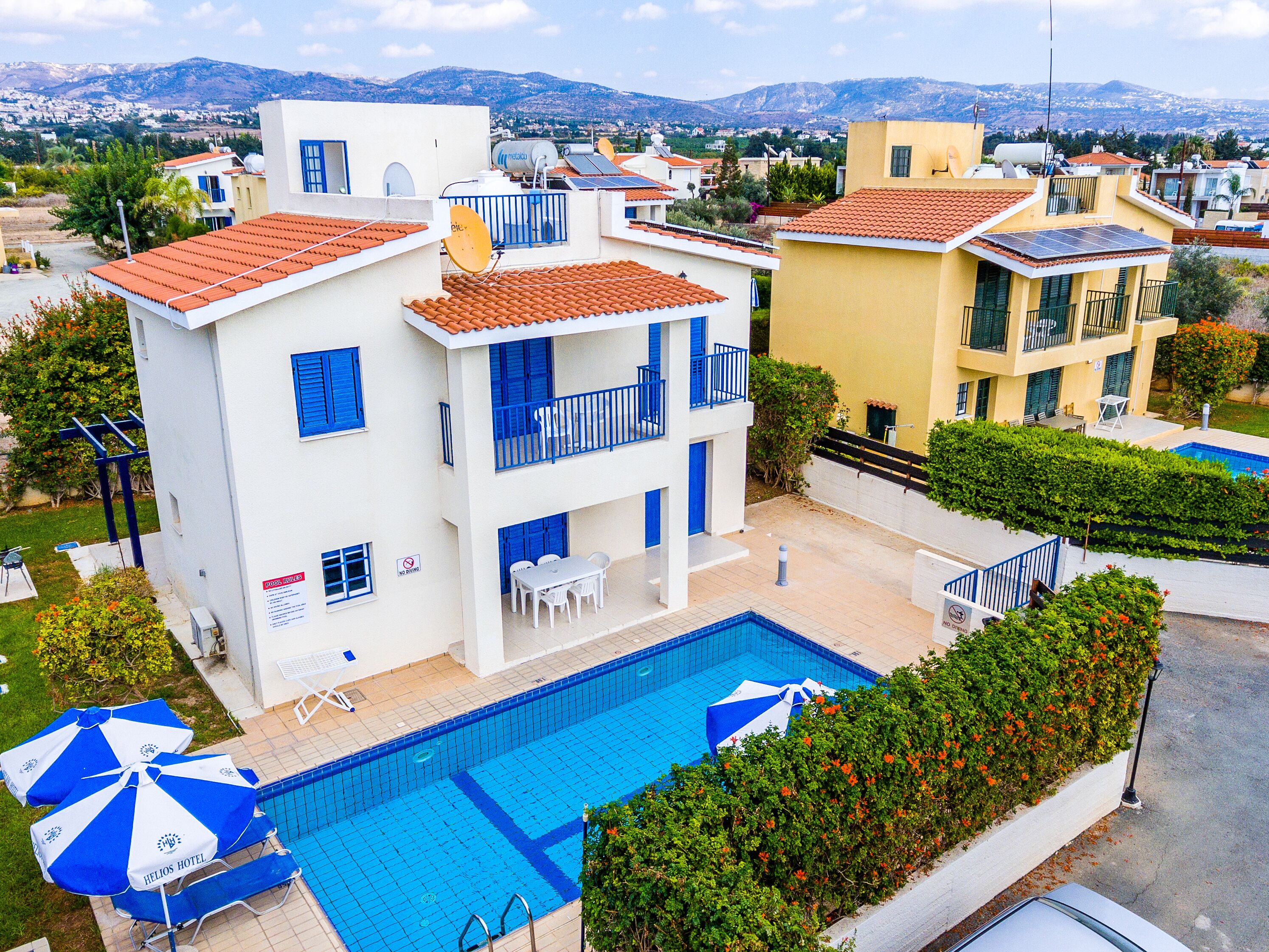 Un hotel con piscina, mobiliario exterior y vistas del entorno.