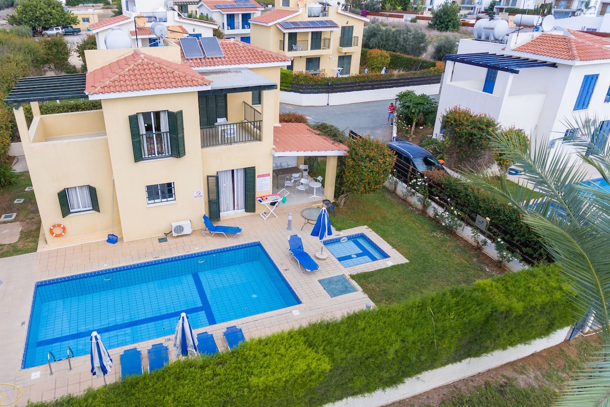 A residential building with a swimming pool, multiple balconies, and a garden area.