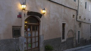 A building with a wooden door and two wall-mounted lights. - Hotel Can Font (Sineu)