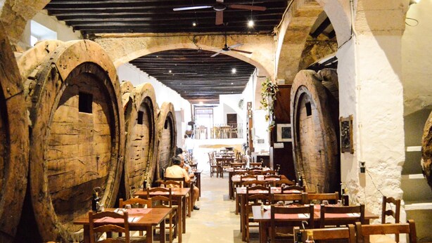 A restaurant with stone arches, wooden tables, and chairs. - Hotel Can Font (Sineu)