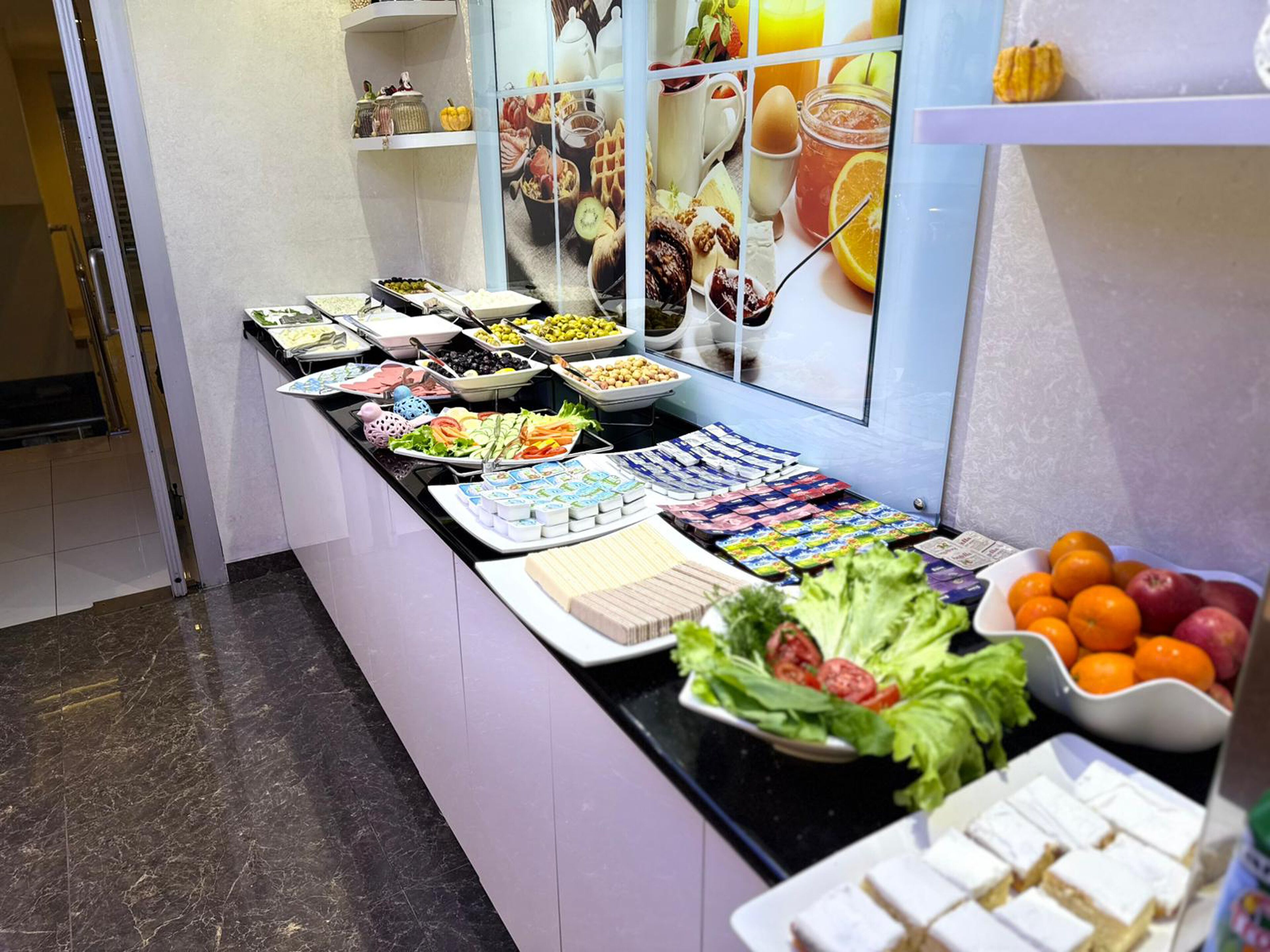 A buffet with various food items including fruits, vegetables, and dairy products.