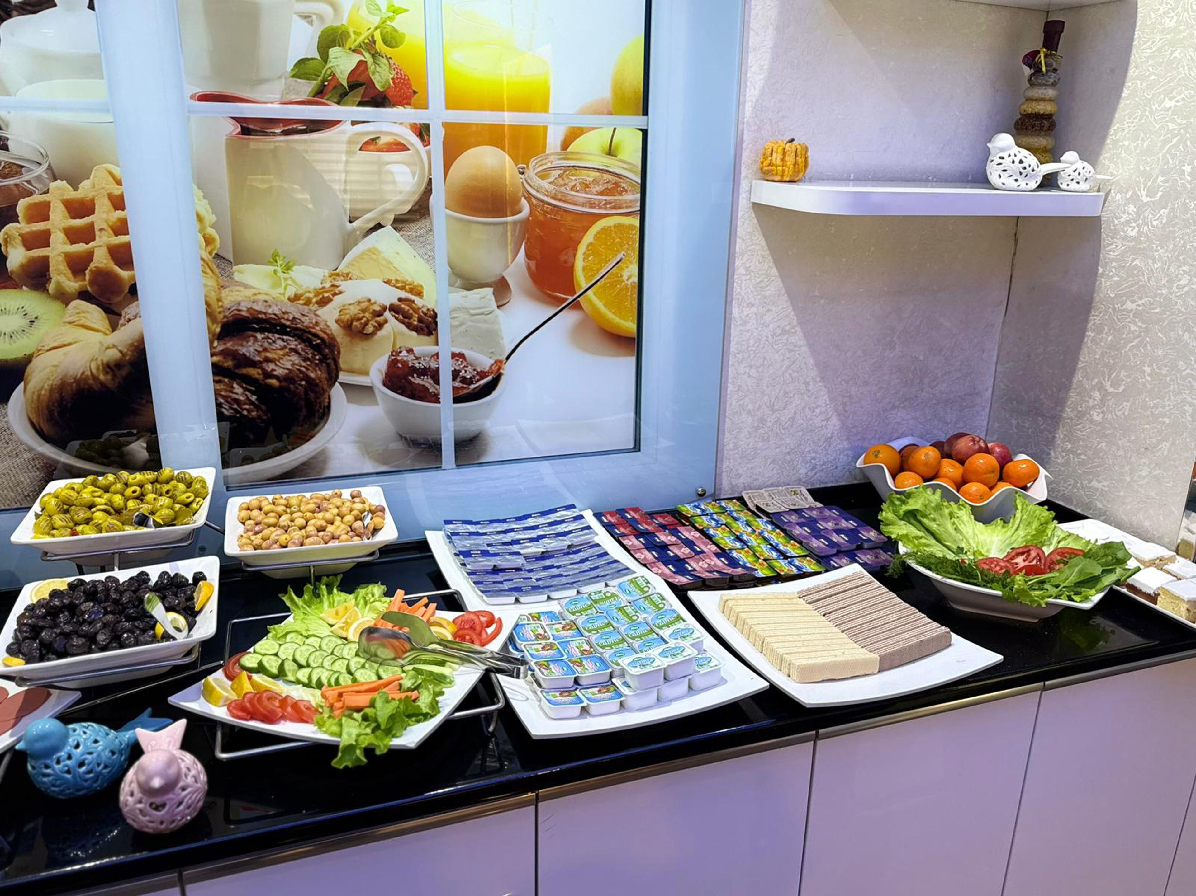 Buffet-pöydässä on tarjolla monenlaista ruokaa, kuten hedelmiä, vihanneksia, juustoja ja pakattuja välipaloja.