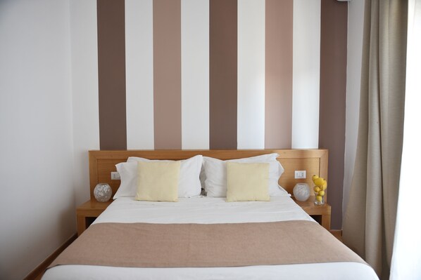 Driepersoonskamer | Een minibar, een kluis op de kamer, een bureau