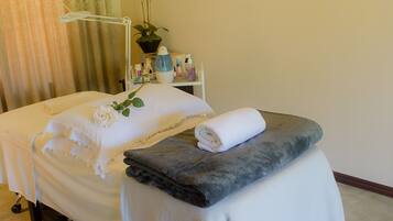A neatly arranged bedroom with a bed, a bedside table, a hanging light fixture, and a black and white patterned rug.