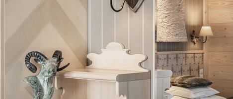A bedroom with a wooden headboard, a bedside lamp, a decorative sculpture, and a fluffy throw blanket.