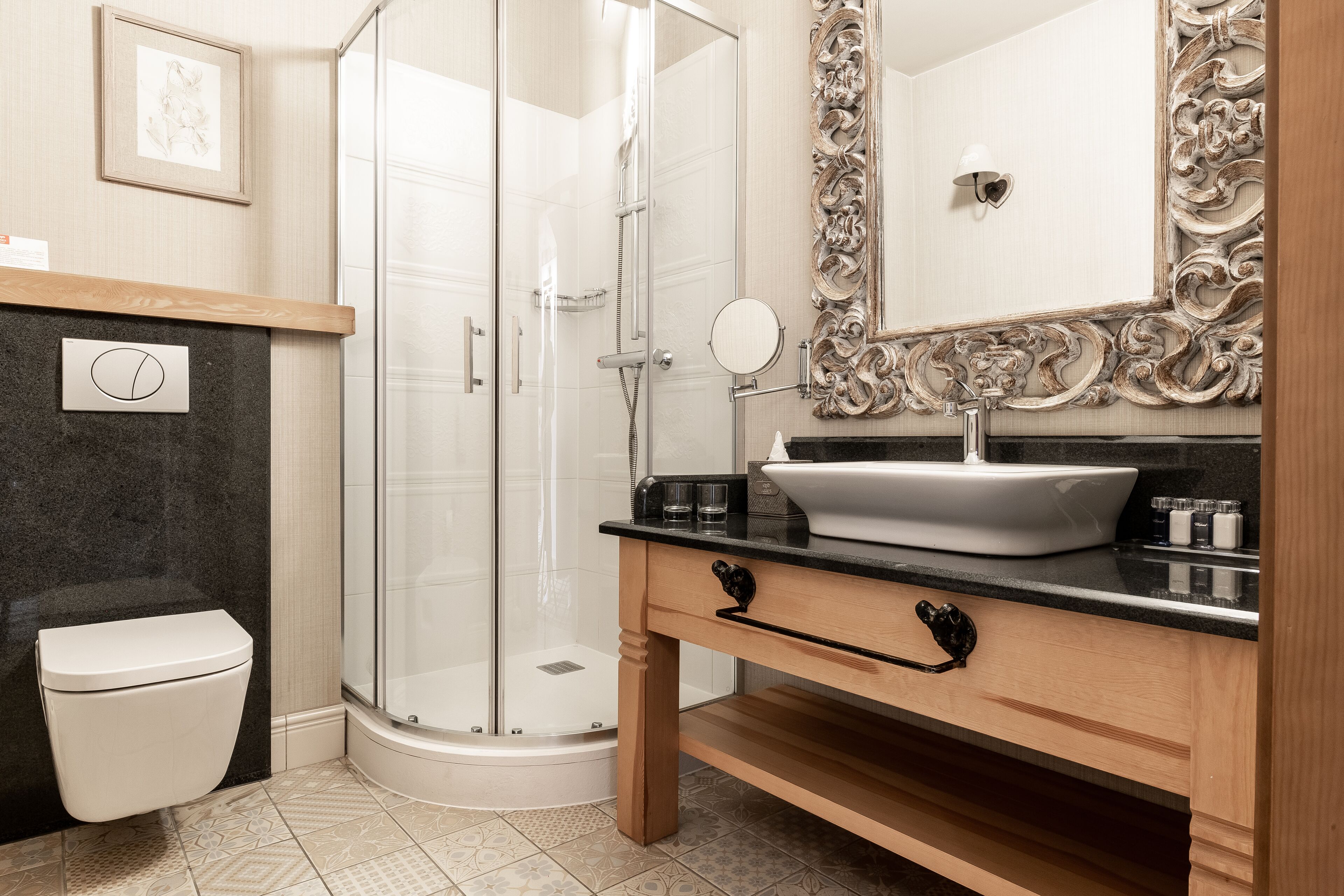 A modern bathroom with a glass shower enclosure, a white toilet, a vanity with a large mirror, and a sink.