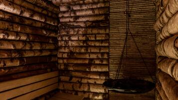 Interior de una cabaña de troncos con un banco de madera y una pila colgante.