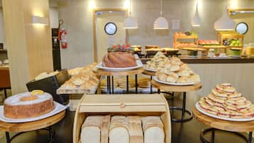 A bakery display with various baked goods, including pastries and bread, arranged on wooden stands.