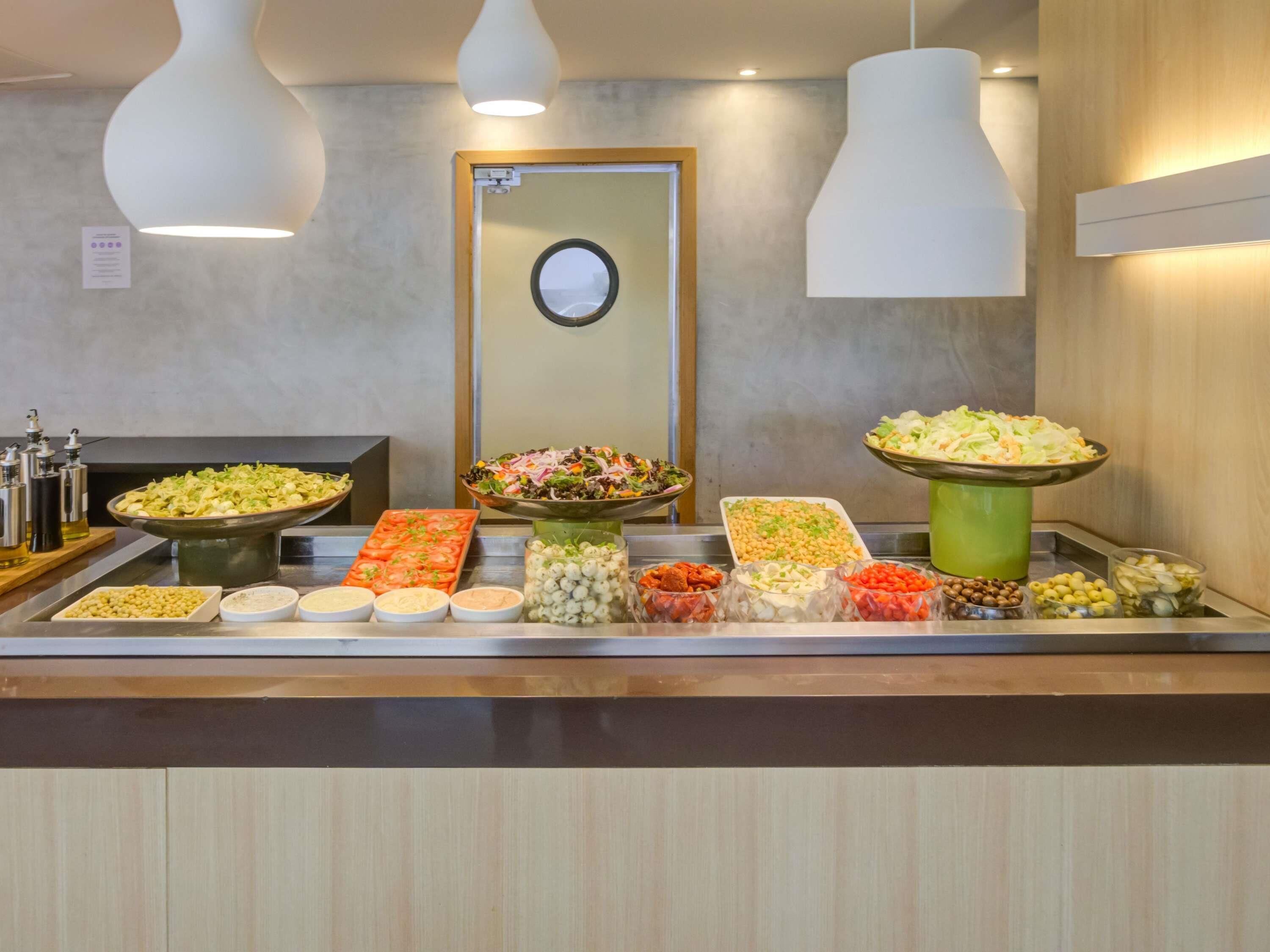 A buffet with various food items and condiments.
