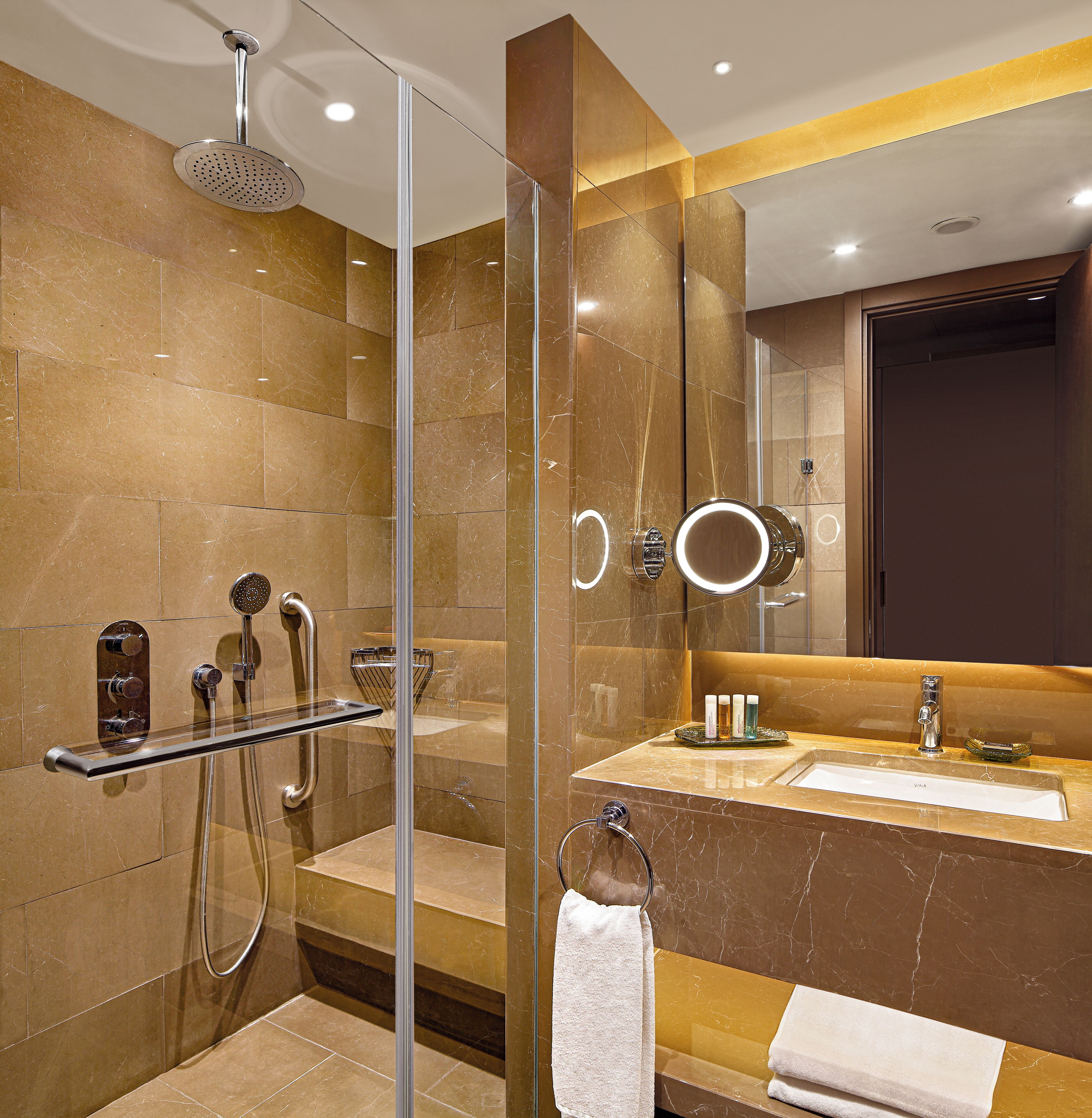 A modern bathroom with a glass shower enclosure, a vanity with a mirror, and a towel rack.