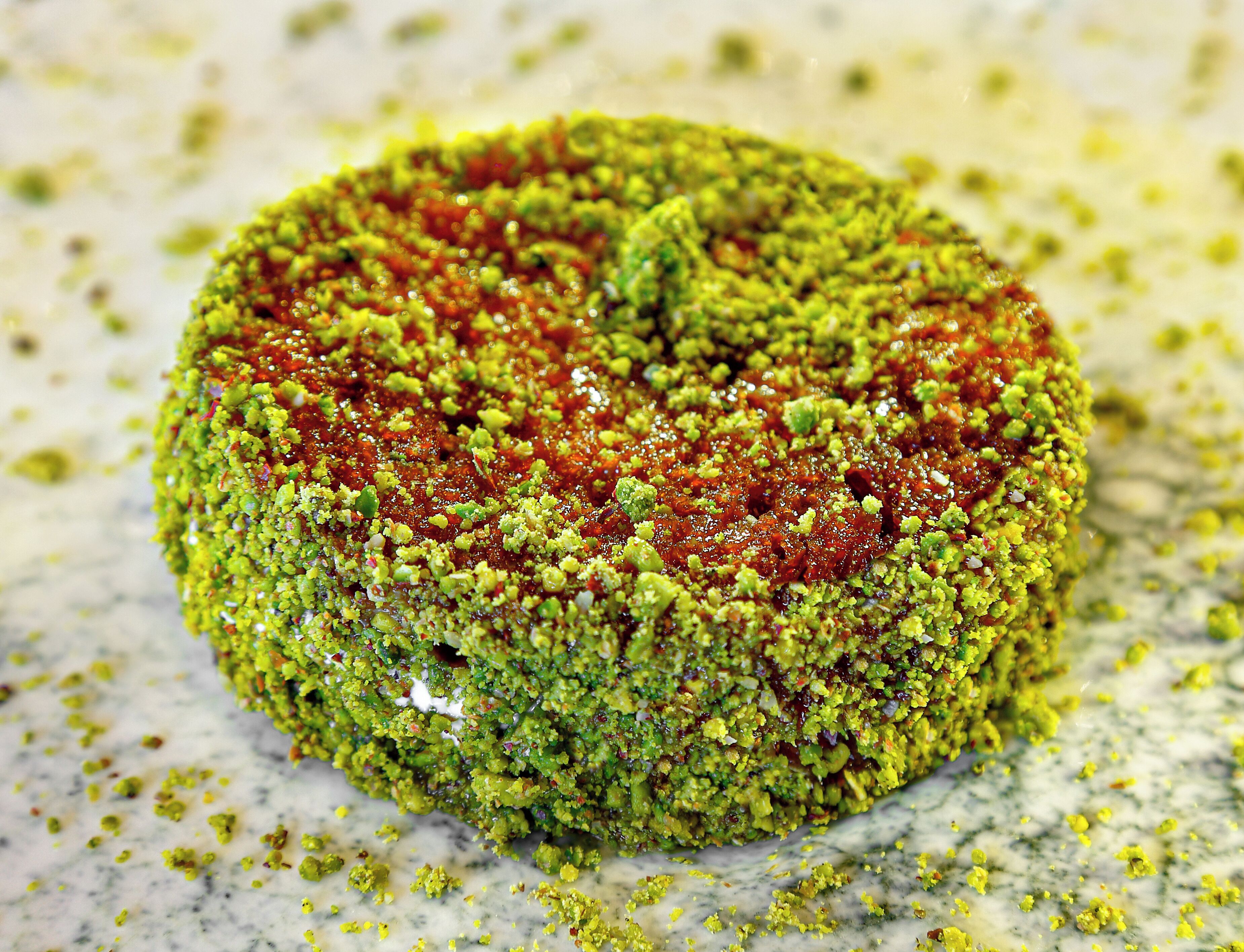 A round object with a textured surface, possibly a food item, on a marble surface.