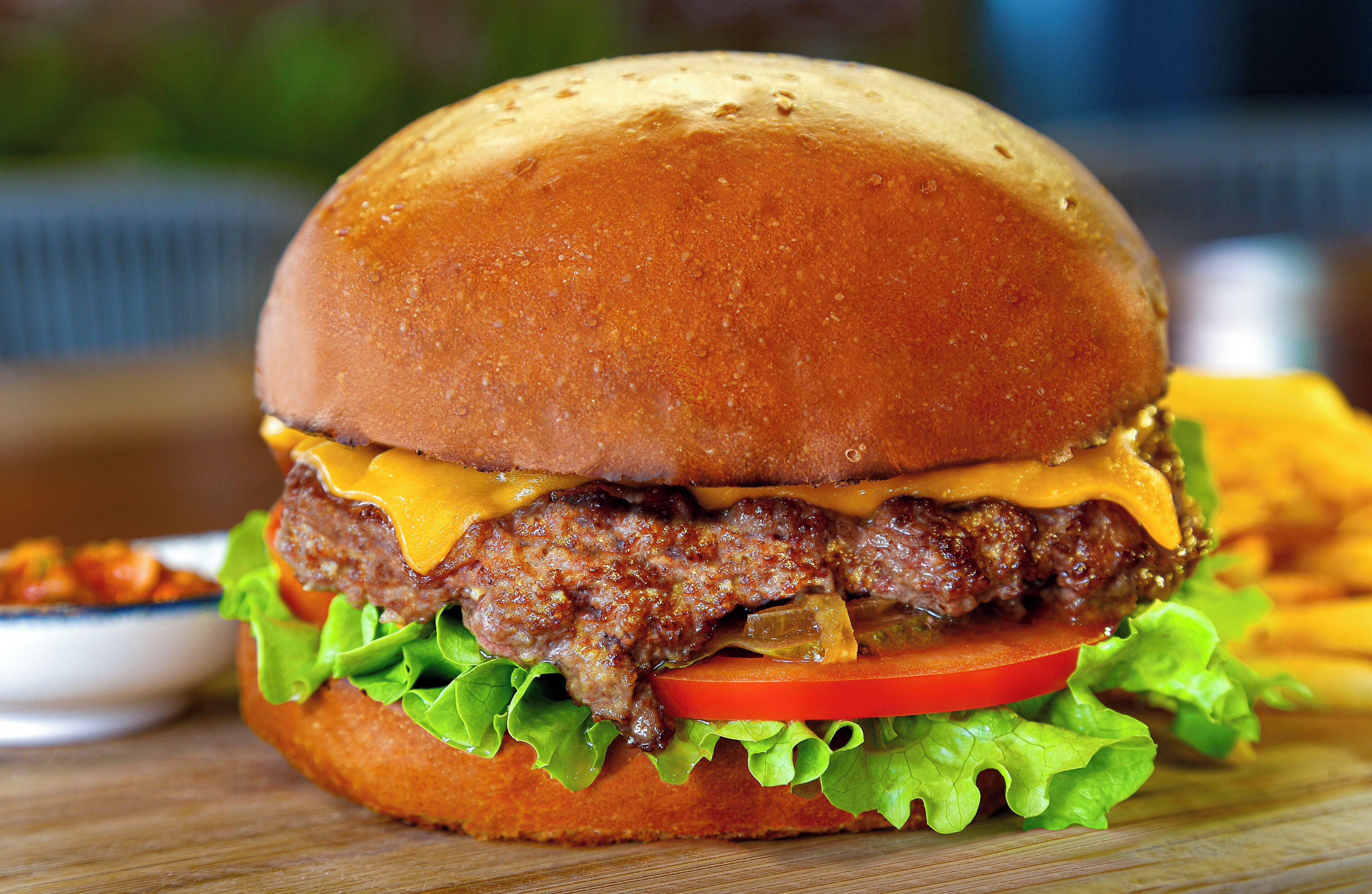 A hamburger with a beef patty, cheese, lettuce, tomato, and a bun.
