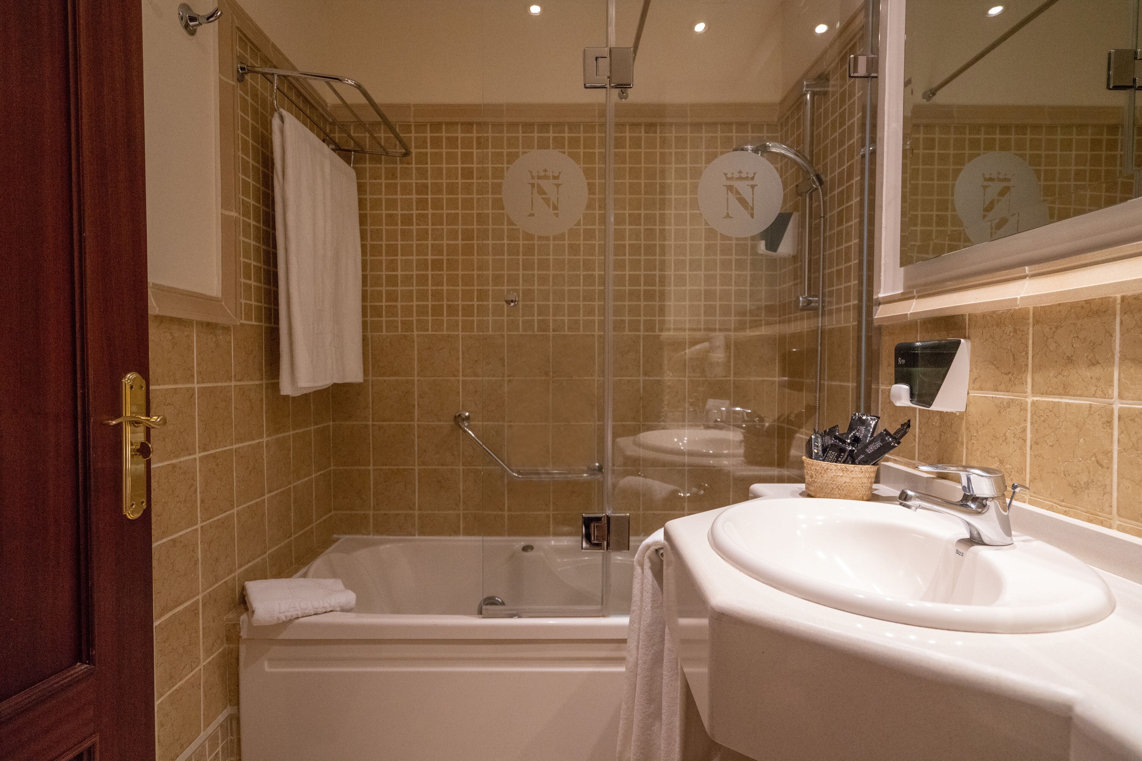 Une salle de bain équipée d’une baignoire, d’un lavabo et d’une douche à parois en verre.