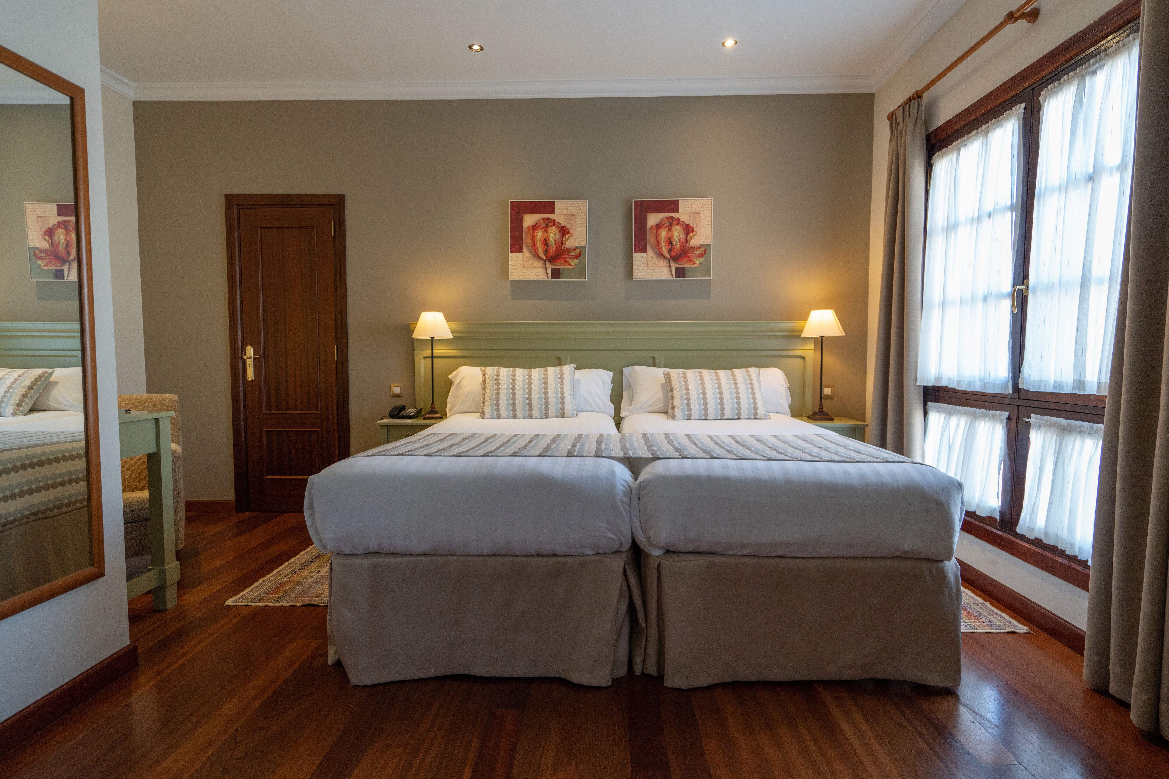 Una cama doble con cabecera de madera, una mesita de noche y una lámpara.