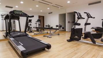 A gym with treadmills, elliptical machines, and weight equipment.
