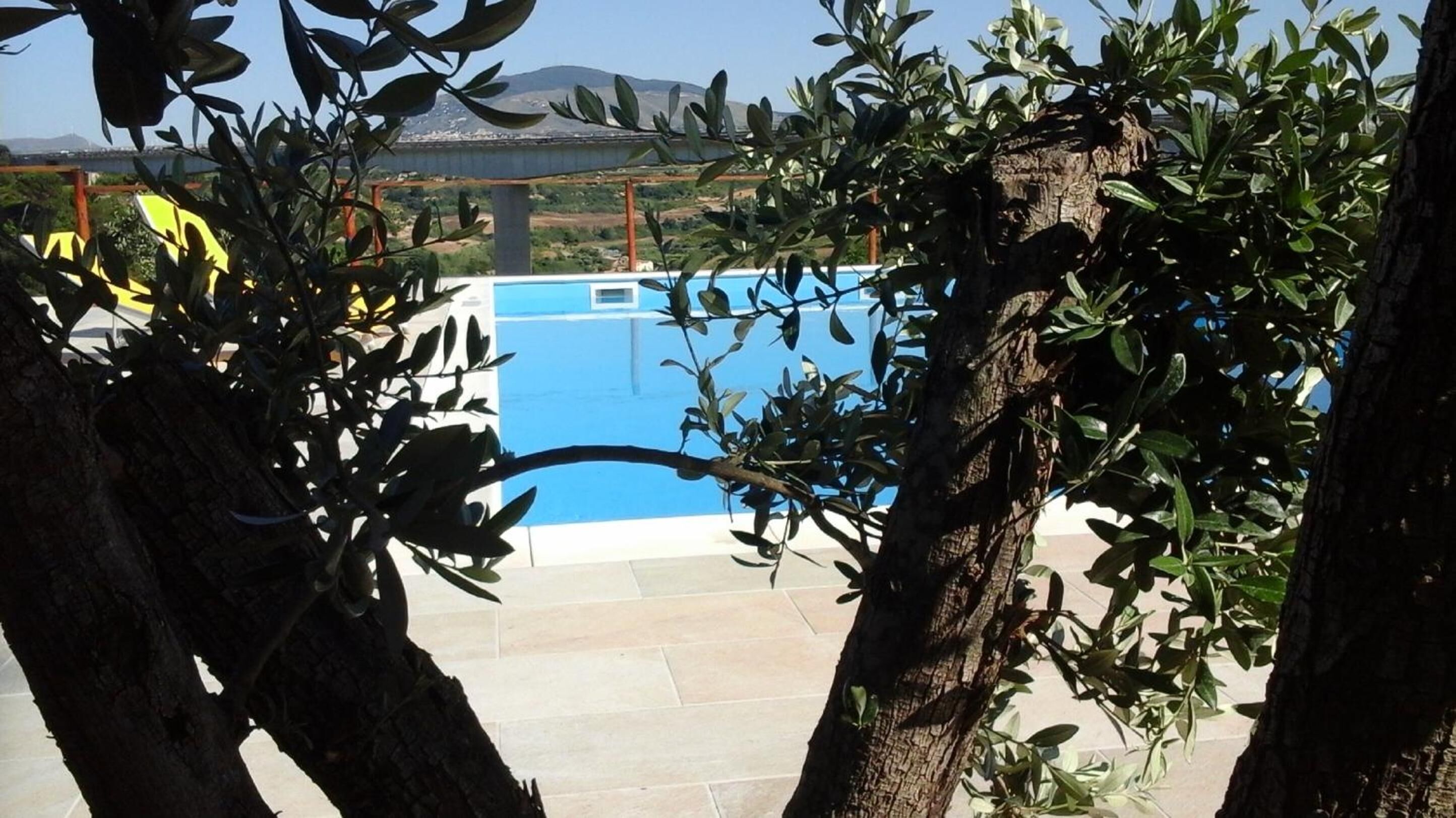 A pool with a view of a bridge and mountains in the background.