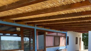 An outdoor covered area with wooden beams, benches, and a tiled floor. - B&B Pelagos (Castellammare del Golfo)