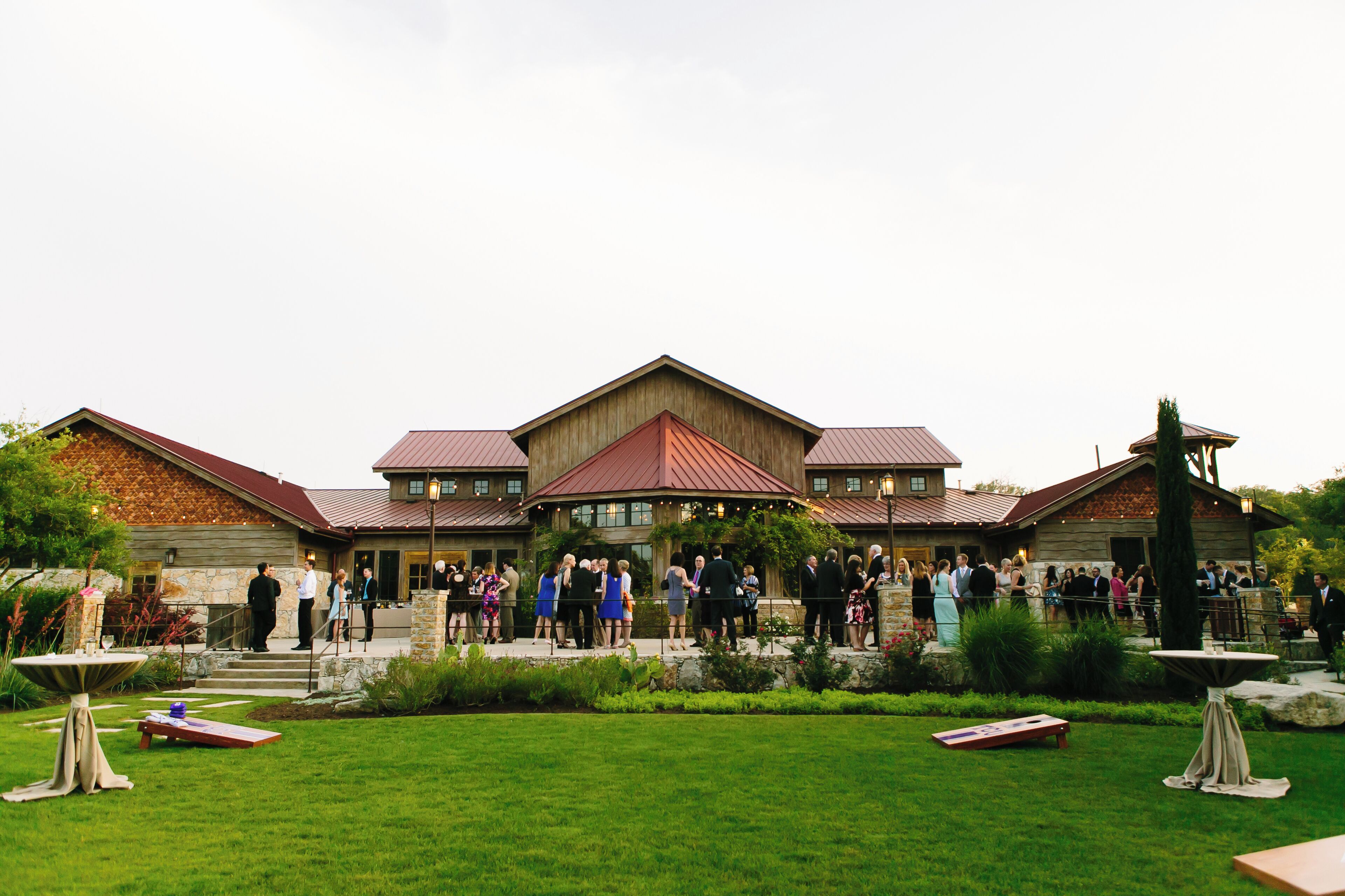 A large building with a central entrance and multiple wings, surrounded by a well-maintained lawn and garden.
