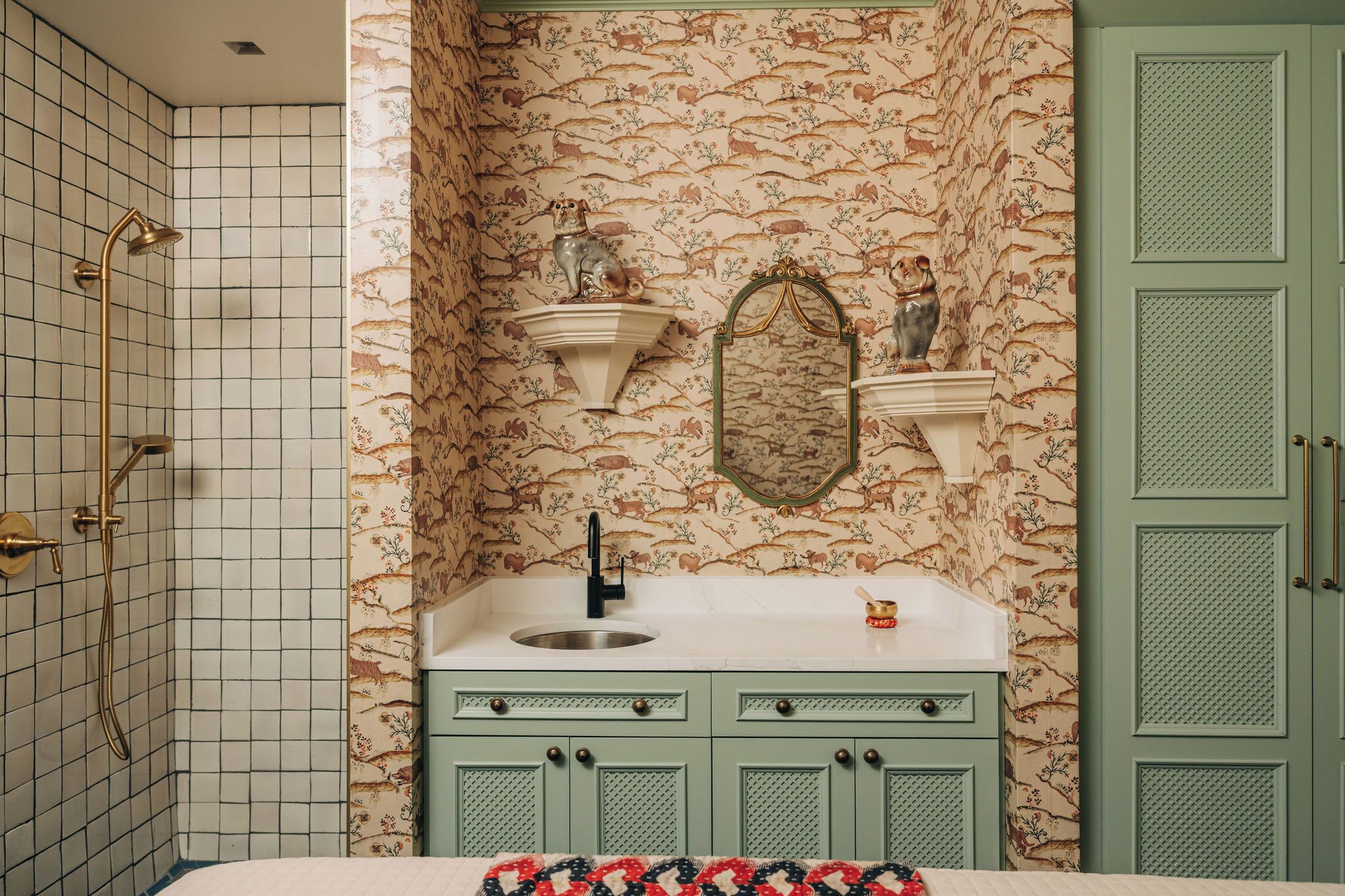 A bathroom with a shower, sink, and green cabinets.