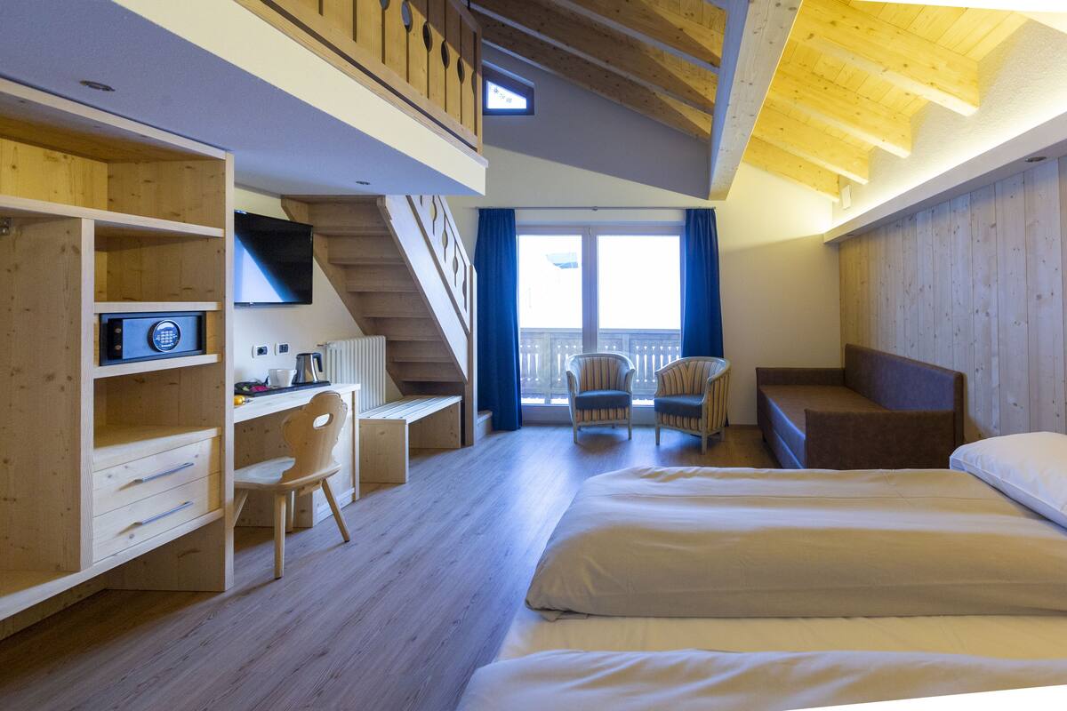 Habitación familiar, balcón | Edredón, minibar, caja de seguridad en la habitación y escritorio