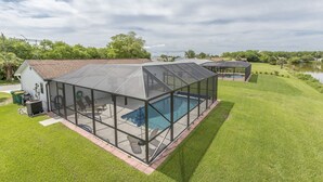 Ein modernes Haus mit einem überdachten Pool und einer überdachten Terrasse.