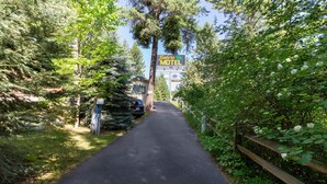 A road leading to a motel surrounded by dense greenery. - Timbers Motel (Bigfork)
